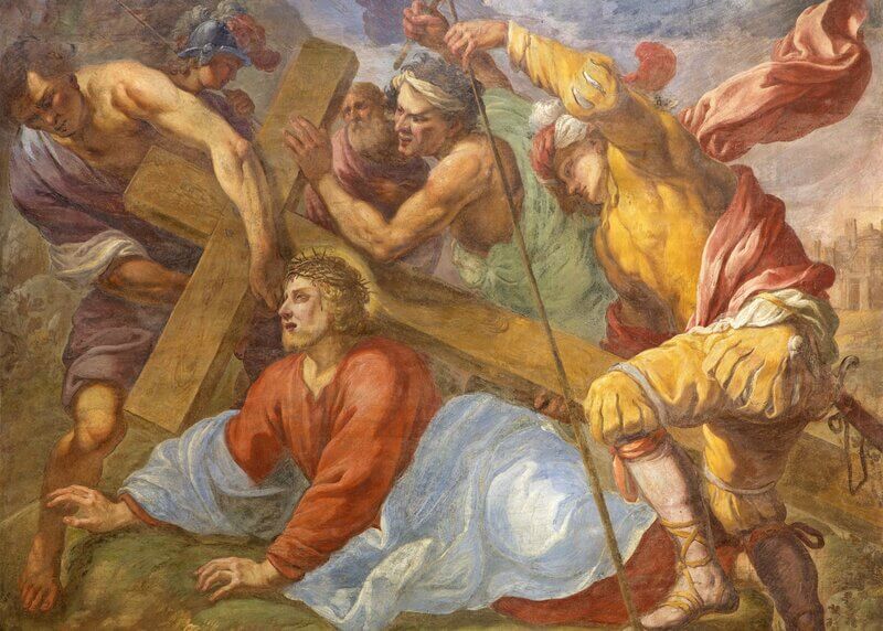 Jesus falls under the cross, and Simon of Cyrene starts to carry his cross for him.