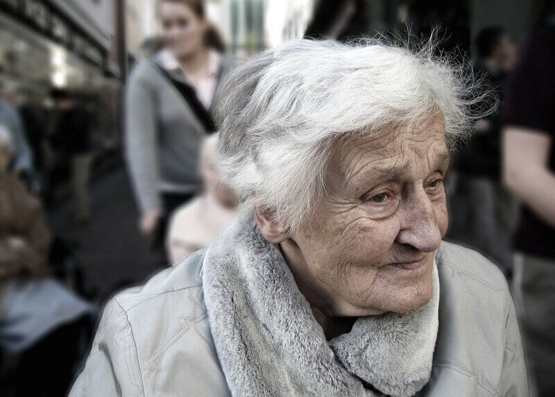 Poor homeless elderly woman.