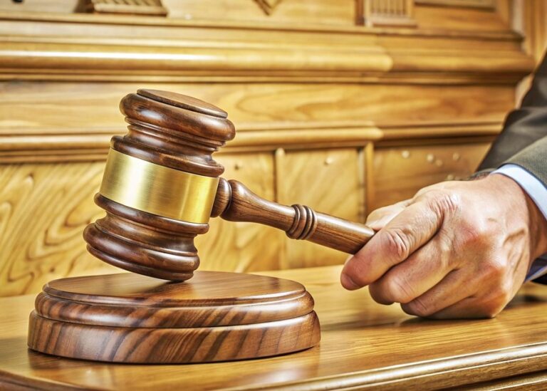 Courtroom scene with a judge putting the gavel down, suggesting that the accused did not settle maters quickly with his accuser but had to go to court to face the judge