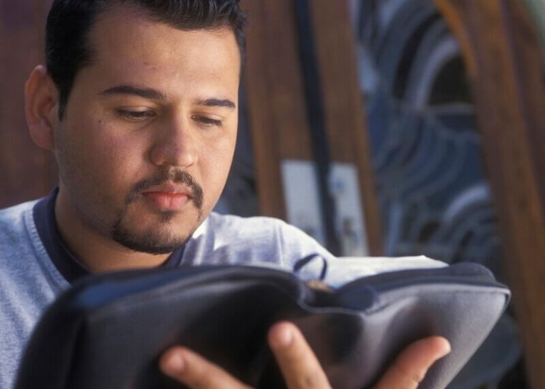 Young man reading the Bible and applying sound Bible interpretation methods to avoid Bible interpretation errors.